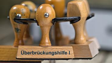Bild: picture alliance / SULUPRESS.DE/Torsten Sukrow Ein Stempel trägt die Aufschrift "Überbrückungshilfe".