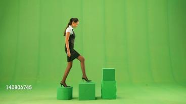 Eine Frau steigt in grüner Kulisse von Stufe zu Stufe aufwärts.