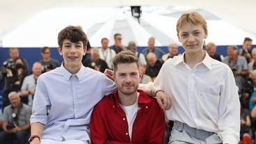 Bild: picture alliance/dpa/MAXPPP | Patrice Lapoirie Lukas Dhont und die beiden Hauptdarsteller des Films schauen in die Kamera.