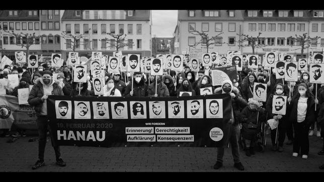 Bild: rise and shine cinema Menschen halten ein Banner und Schilder mit Gesichtern hoch