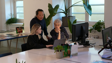 Johanna Keimeyer und zwei Mitarbeitende reden vor einem Laptop.