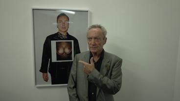 Bild: WDR Udo Kier zeigt auf ein Foto von sich selbst mit weiblichen Brüsten.