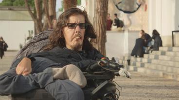 Ein Mann im Rollstuhl gibt ein Interview