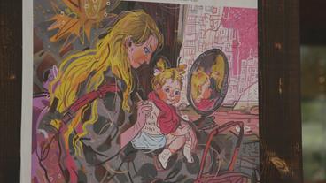 Ein buntes Wandbild zeigt eine blonde Frau imt einm Kind auf ihrem Schoß