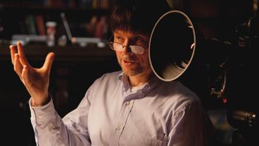 Bild: Ken Burns Ein Mann erklärt, im Hintergrund eine Kamera