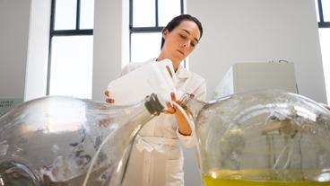 Eine Frau mischt im Labor Flüssigkeiten