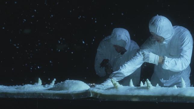 Zwei  Männer in weißen Schneeanzügen auf einer Theaterbühne