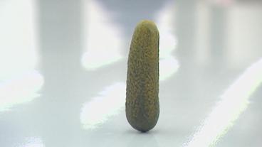 Eine saure Gurke steht auf einem Sockel