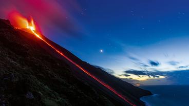 Lava fließt an einem Vulkan herunter