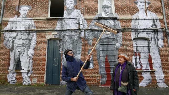 Bild: Agnès Varda-JR-Ciné-Tamaris, Social Animals 2016/Agnès Varda/JR Zwei Personen vor einer Wand mit überlebensgroßen Bildern von Menschen