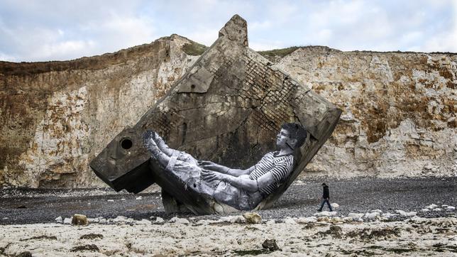 Bild: Agnès Varda-JR-Ciné-Tamaris, Social Animals 2016/Agnès Varda/JR ein Kliff, auf das ein überlebensgroßes Foto von einem Mann aufgetragen wurde