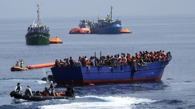 Bild: picture alliance / dpa Deutsche Marinesoldaten fahren mit einem Boot zu einem überfüllten Flüchtlingsboot auf dem Mittelmmer.