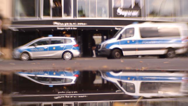 Bild: BR Zwei Polizeiwagen parken vor einem Café