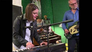 Bild: NDR Eine junge Frau mit braunen Haaren steht an einem Keyboard und spielt, im Hintergrund ein grauhaariger Mann mit Gitarre.