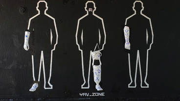 Ein Kunstwerk der Gruppe YAV: Man sieht Silhouetten an einer Wand mit Protesen.