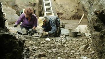 Zwei Menschen bei Ausgrabungsarbeiten in der Els-Trocs-Höhle