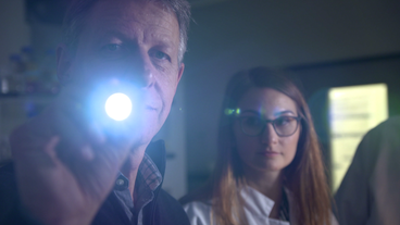 Wissenschaftler leuchtet mit LED-Lampe in Kamera