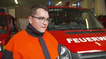 Ein Mann steht vor einem Feuerwehrauto