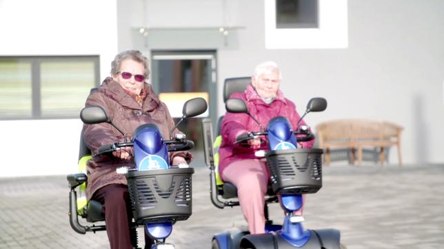 Seniorinnen fahren Scooter