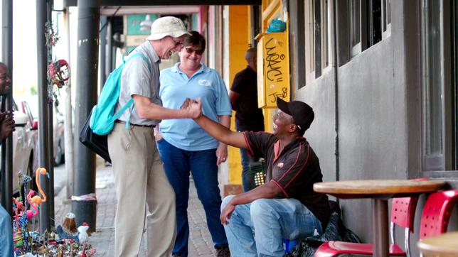 Ein Mann begrüßt einen Straßenhändler per Handschlag