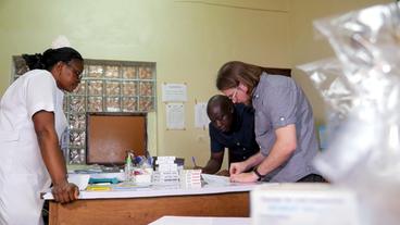 Fidelis Nyaah und Simon Schäfermann sammeln Medikamente in einer Krankenhaus-Apotheke