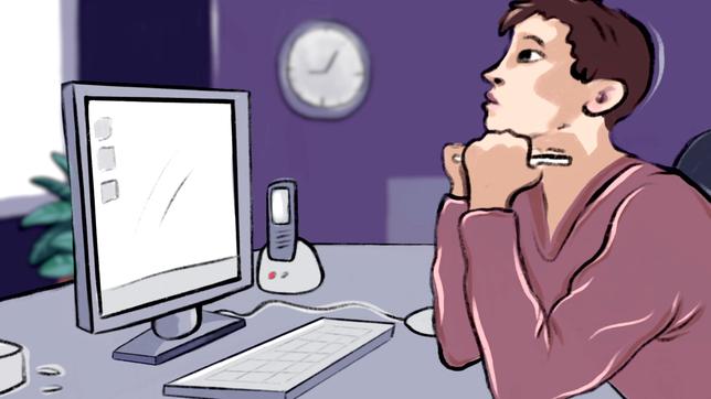 Eine Person sitzt an einem Computer und schaut gelangweilt aus dem Fenster.