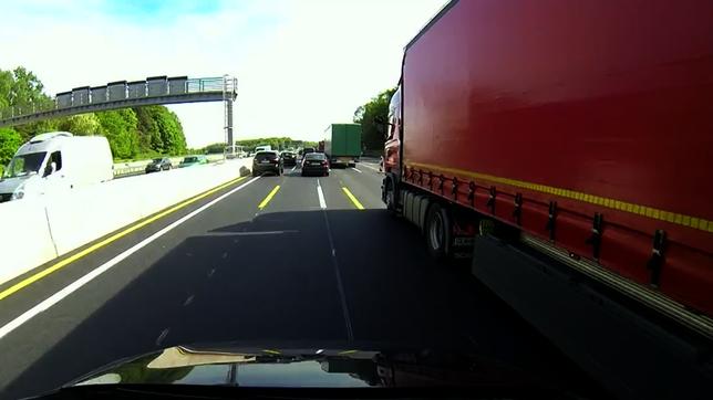 Auto in einer Autobahnbaustellen fährt an einem Laster vorbei