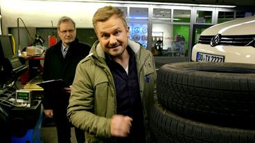 Bild: WDR Moderator Burkhardt Weiß mit Experte hinter einem Reifenstapel