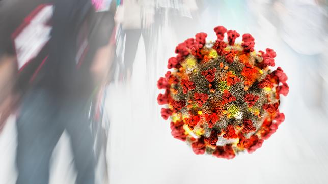 Ein Virus schwebt vor einer Menschenmenge (Fotomontage).
