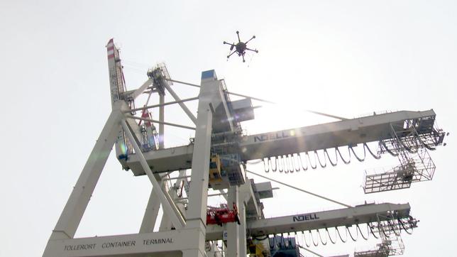 Eine Drohne inspiziert im Hamburger Hafen eine Containerbrücke.