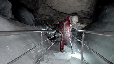 Höhlenarbeiter pickeln Eis von Weganlagen
