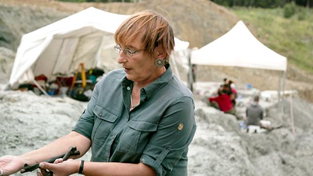 Paläontologin Madelaine Böhme hält eine gefudene Elle an ihren Unterarm.