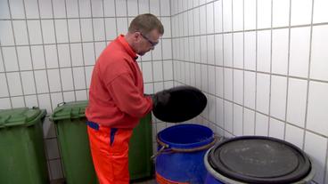 Bild: NDR Mann schaut in Tonnen mit Alspeiseöl.