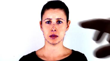 Gesicht einer Frau mit blauen Punkten im Gesicht.