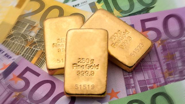 Kleine Goldbarren liegen auf Euro-Geldscheinen