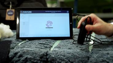 Bild: BR Scanner wird auf Jeansballen gehalten, Bildschirm zeigt stilisierten Fingerabdruck.