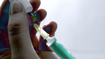 Impfstoff wird in eine Spritze aufgezogen