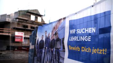 "Lehrlinge gesucht" Banner auf einer Baustelle