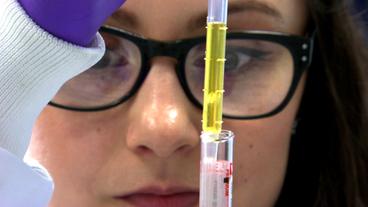 Bild: NDR Forscherin zieht Blut aus einem Reagenzglas.