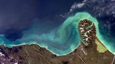 Bild: ESA Umrisse eines Bergs, von dem das Schmelzwasser blau ins Meer fließt.