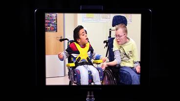 Zwei Kinder im Rollstuhl interagieren mit dem Motion Composer. 