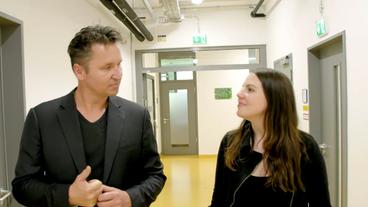 Bild: WDR Lena und Prof. Herzig im Gespräch, während sie einen Gang entlang gehen.
