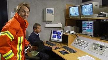 Dennis Wilms mit Mann von der Leitwarte vor Computerbildschirmen und Monitoren