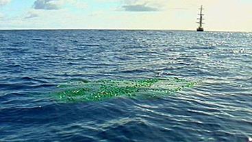 Plastikmüll treibt im Meer, im Hintergrund die Kaisei