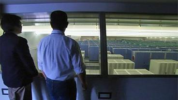 Zwei Männer schauen in den Raum mit dem Supercomputer des Japanischen Wetterdienstes