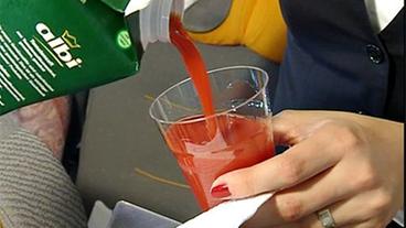 Stewardess schenkt Tomatensaft ein