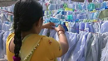 Eine Frau hängt Plastiktüten auf