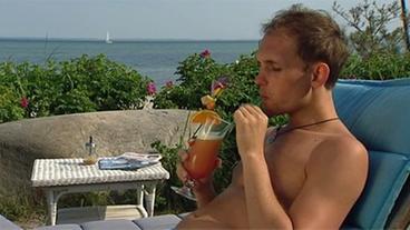 Bild: NDR Cocktail trinkender Mann am Strand