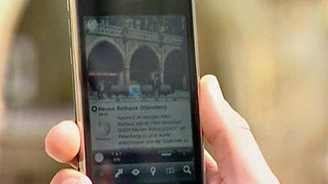 Bild: BR Großaufnahme Handy Display mit Bild Münchner Rathaus und Kurztext aus Wikipedia
