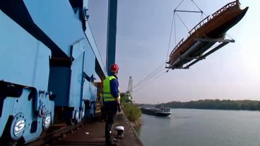 Ein Containerkran setzt das Schiff ins Wasser